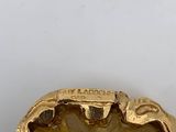 an image of a close up of a gold buckle on a white surface