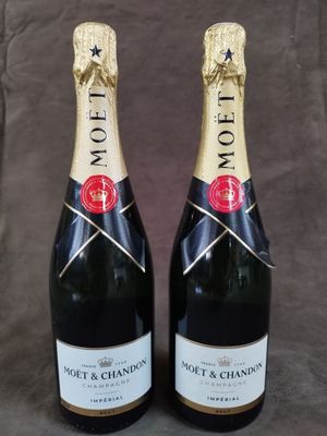 deux bouteilles de champagne Moët & Chandon sur fond gris