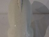 a white vase sitting on a white sheet on a table