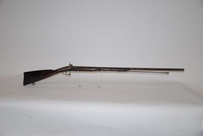 a rifle on a table with a white background