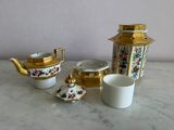 a white and gold tea set on a marble table
