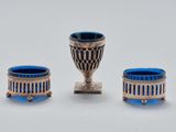 trois objets en verre argenté et bleu posés sur une table