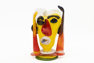 sculpture en verre aux couleurs vives représentant un homme avec des skis sur la tête