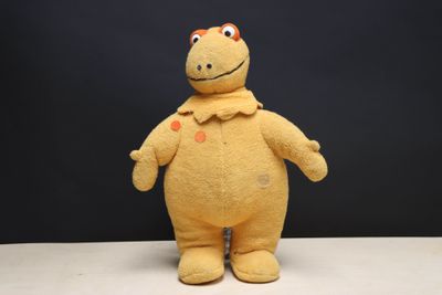 a yellow stuffed animal that is standing on a table