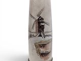 a tall vase with a windmill on it