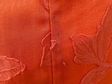 close up of a woman ' s orange dress with a floral design on it