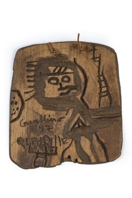carved wooden plaque with a drawing of a man holding a knife
