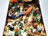 toy figurines in a tin on a table with a white background