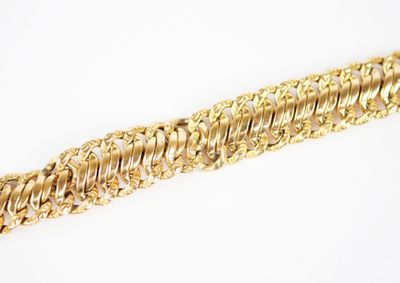 a close up of a gold bracelet on a white surface