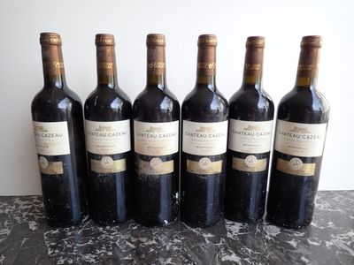 six bottles of wine are lined up in a row on a table