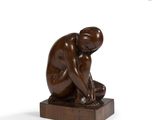 statue of a man kneeling on a wooden base with his hands on his knees