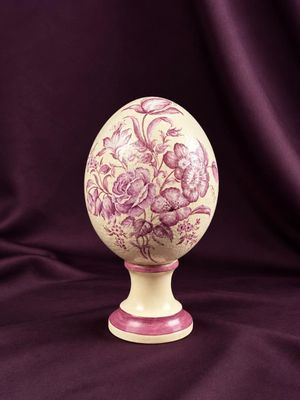purple and white vase sitting on a purple cloth with a purple background