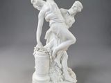 une figurine blanche représentant un homme et une femme avec un seau