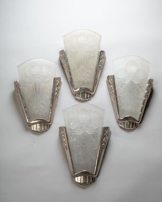 three art deco wall sconces with frosted glass shades on a white background