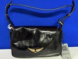 un sac à main en cuir noir orné d'un oiseau doré sur le devant