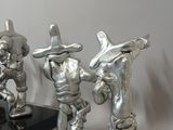 three silver figurines of a cowboy and a cowgirl