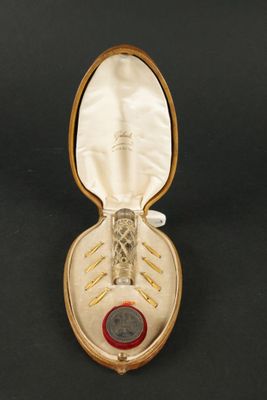 a gold case with a red button inside of it