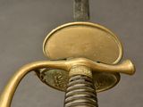 a close up of a sword with a gold handle