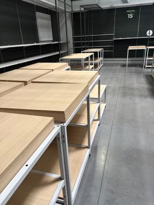 de nombreuses étagères en bois au milieu d'une pièce