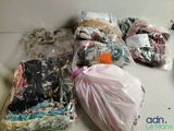 de nombreux sacs de vêtements posés par terre à côté d'une paire de ciseaux