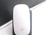 a white mouse sitting on top of a desk next to a black wall