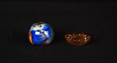 deux petits objets en verre posés sur une surface noire