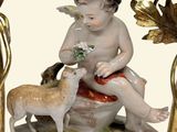 a figurine of a boy sitting on a rock with a goat