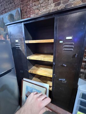 a man that is putting something in a cabinet