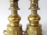 pair of antique brass oil lamps on a white background