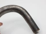 a hand holding a metal pipe on a white surface