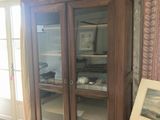 a large wooden cabinet with glass doors in a living room