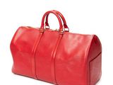 the large red duffel bag is sitting on a white surface