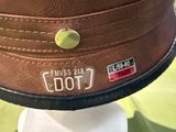 a brown hat on a white pedestal with a green table cloth