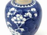 a blue vase with white flowers on it on a white surface