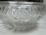 a glass bowl with a silver lid sitting on a table