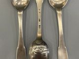 three spoons and two spoons are sitting on a table