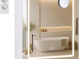 une photo d'une salle de bains avec un grand miroir et une baignoire