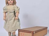 a doll that is standing next to a box