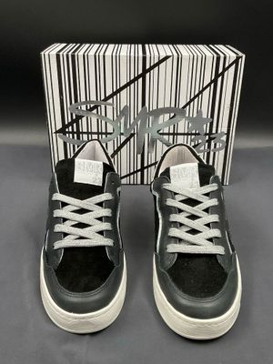 black and white sneakers with white laces and a box of black and white shoes