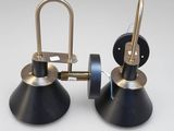 une paire de lampes noires et dorées posées sur une surface blanche