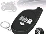 a close up of a car tire pressure gauge with a keychain