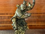 une statue représentant un homme à cheval posée sur une table en bois