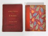 an old book sitting on top of a white table next to a red book