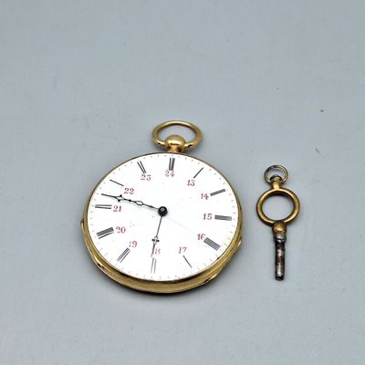une montre à gousset en or à laquelle est attachée une clé