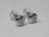 une paire de boucles d'oreilles en diamant posées sur une surface blanche
