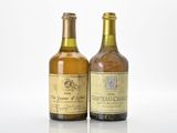 two bottles of wine sitting next to each other on a white surface