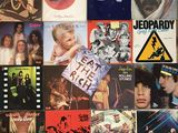 many different album covers on the wall of this room