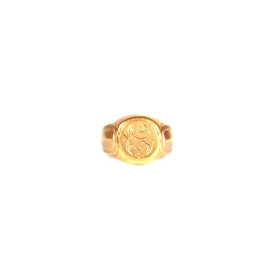 un gros plan d'une bague en or sur laquelle est gravé un smiley