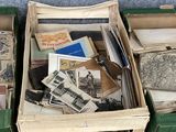 une valise verte remplie de livres et de papiers, posée par terre