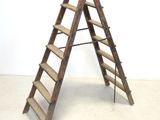 a wooden ladder that is leaning against a white wall